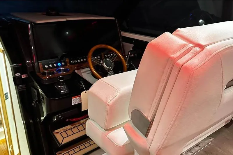 Slide: The Image of 2023 Tiara Yachts 43 LS helm with white seating and wooden steering wheel. - 18