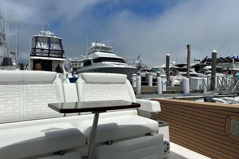 Slide: The Image of 2023 Tiara Yachts 43 LS at marina, featuring luxurious white seating and wooden accents. - 19