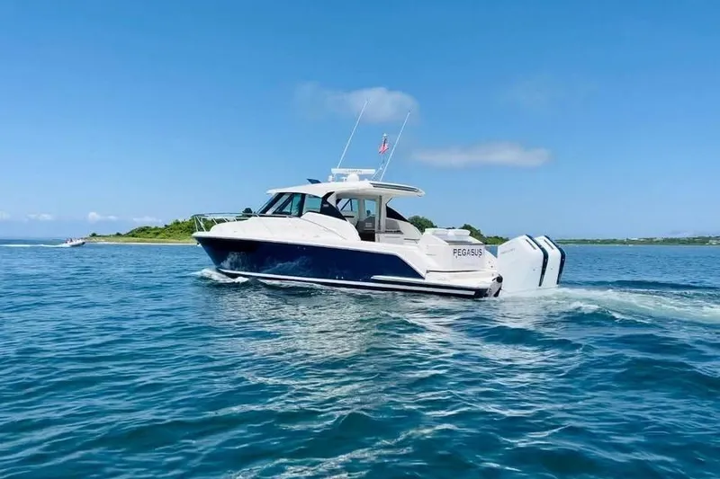 Slide: The Image of 2023 Tiara Yachts 43 LS cruising on clear blue waters under a sunny sky. - 2
