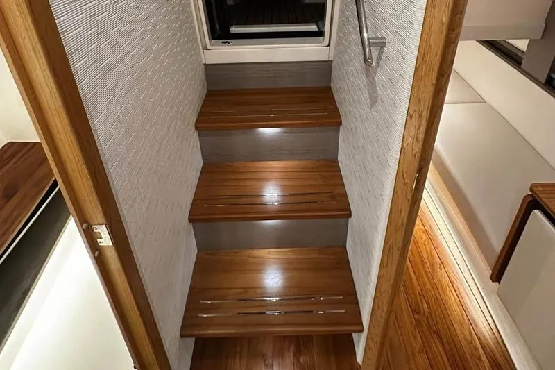Slide: The Image of Interior stairs of 2023 Tiara Yachts 43 LS, featuring sleek wooden design and modern finish. - 21