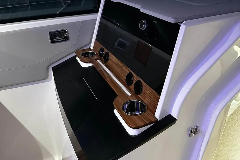 Slide: The Image of 2023 Tiara Yachts 43 LS interior console with wood accents and cup holders. - 22