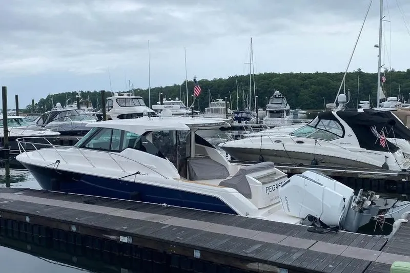 Slide: The Image of 2023 Tiara Yachts 43 LS docked at a marina with other boats. - 3