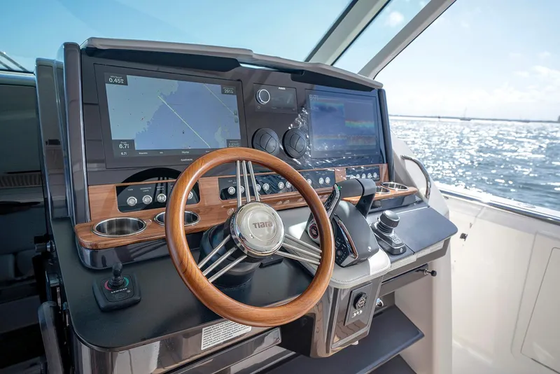 Slide: The Image of Manufacturer Provided Image: 2023 Tiara Yachts 43 LS helm with dual navigation screens and wooden steering wheel. - 4