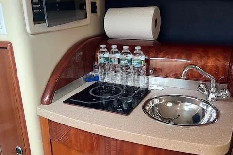 Slide: The Image of 2008 Cobalt 323 boat kitchenette with sink, stove, and water bottles. - 12