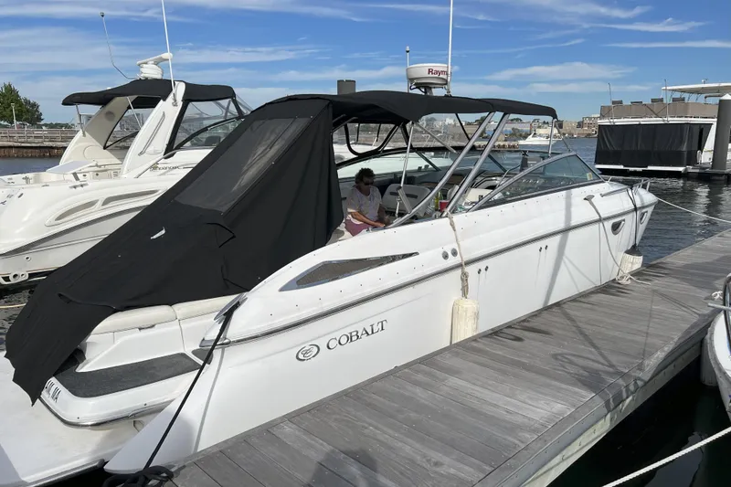 Slide: The Image of 2008 Cobalt 323 boat docked at marina, covered with black canopy. - 6