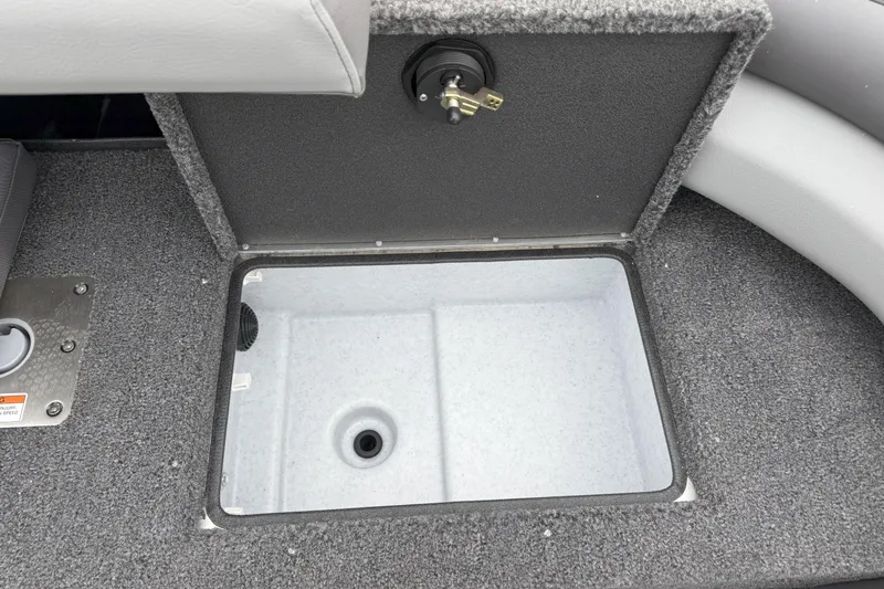 Slide: The Image of Crestliner 1950 Sportfish 2026 boat storage compartment with open lid, gray interior. - 12