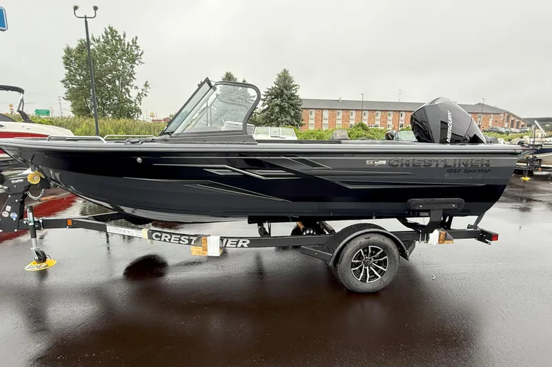 Slide: The Image of 2026 Crestliner 1950 Sportfish boat on trailer, parked outdoors on a rainy day. - 2