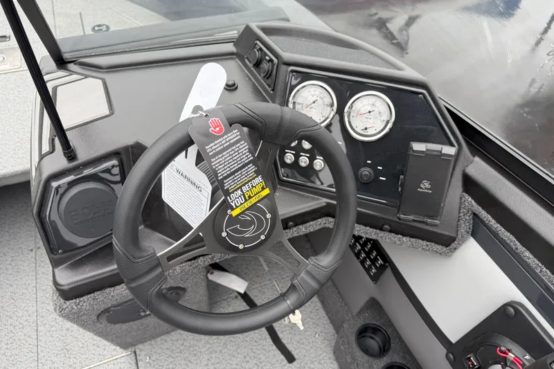 Slide: The Image of 2026 Crestliner 1950 Sportfish dashboard with steering wheel, gauges, and warning tag. - 8