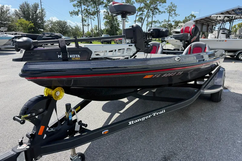Slide: The Image of 2021 Ranger Z518 boat on trailer, featuring Minn Kota Ultrex motor, parked outdoors. - 5