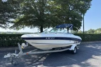 Slide: The Image of 1998 Sea Ray 190 Bow Rider boat on trailer, parked outdoors near trees. - 3