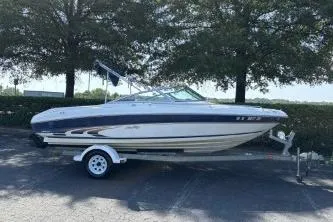 Slide: The Image of 1998 Sea Ray 190 Bow Rider boat on trailer, parked under trees. - 6