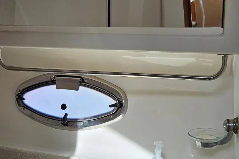 Slide: The Image of Interior of 2002 Carver 410 Sport Sedan with oval porthole and bathroom fixtures. - 16