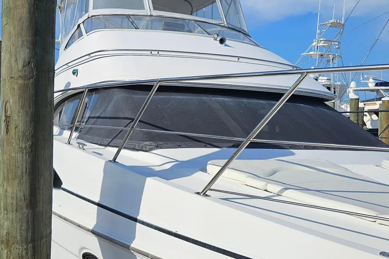 Slide: The Image of 2002 Carver 410 Sport Sedan yacht docked at marina, featuring sleek design and spacious deck. - 17