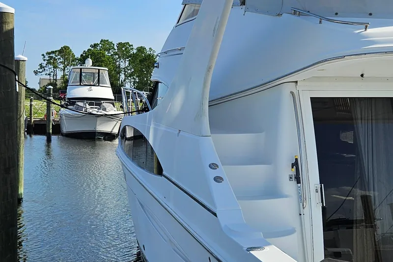 Slide: The Image of 2002 Carver 410 Sport Sedan yacht docked in a serene marina setting. - 18