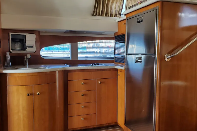 Slide: The Image of Interior of 2002 Carver 410 Sport Sedan yacht with wood cabinetry and modern appliances. - 21