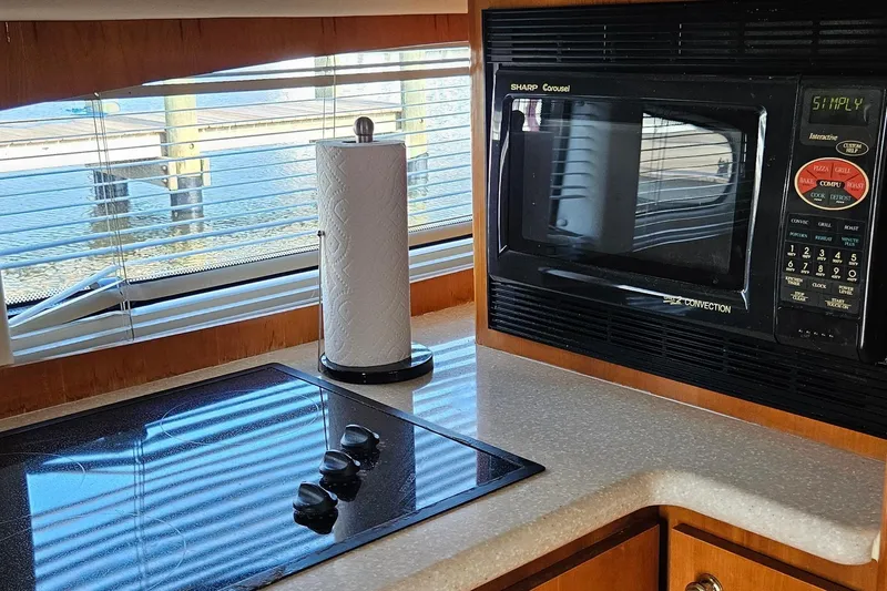 Slide: The Image of Interior of 2002 Carver 410 Sport Sedan with microwave and stovetop in kitchen area. - 24