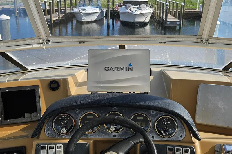Slide: The Image of Helm of 2002 Carver 410 Sport Sedan with Garmin navigation system, docked boats visible. - 4