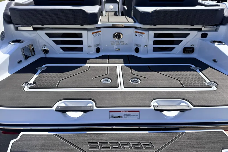 Slide: The Image of 2026 Scarab 235 LX Wake boat rear deck with seating and storage compartments. - 14