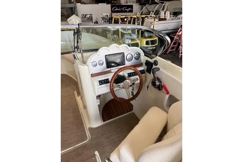 Slide: The Image of 2021 Chris-Craft Launch 27 boat interior with steering wheel and control panel. - 10