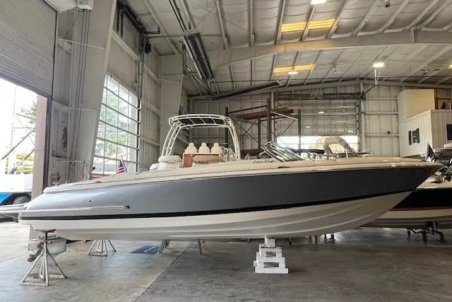 Slide: The Image of 2021 Chris-Craft Launch 27 boat in a spacious indoor storage facility. - 2