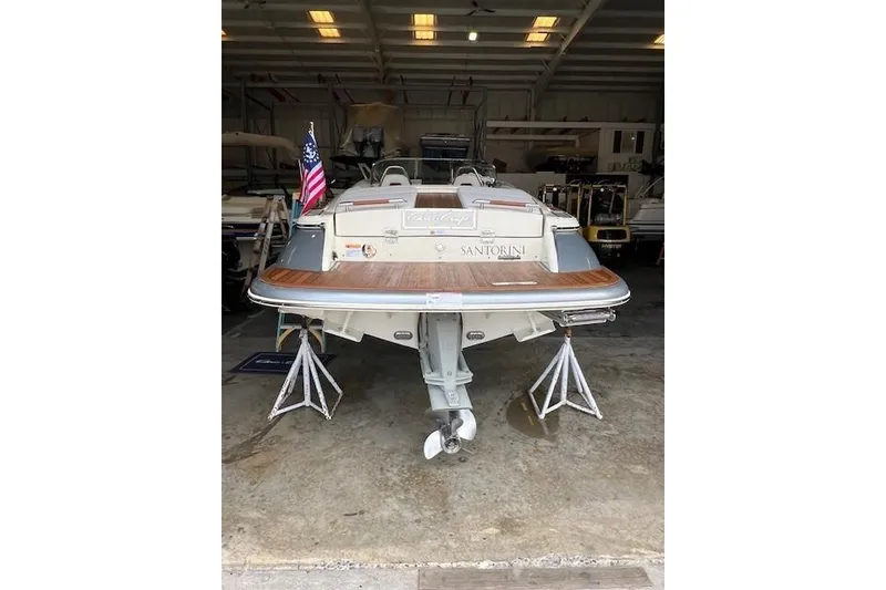 Slide: The Image of 2021 Chris-Craft Launch 27 boat in storage, rear view with American flag. - 3