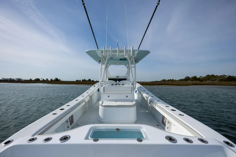 Slide: The Image of 2025 Yellowfin 34 Offshore boat on calm water, showcasing spacious deck and sleek design. - 12
