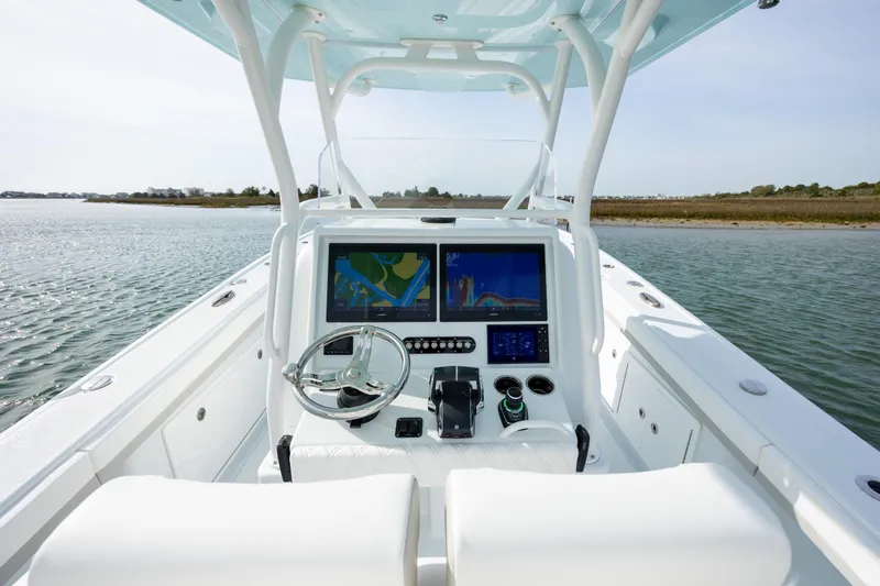 Slide: The Image of 2025 Yellowfin 34 Offshore boat dashboard with navigation screens on calm water. - 17
