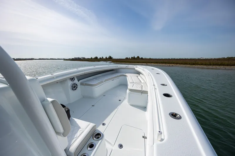 Slide: The Image of 2025 Yellowfin 34 Offshore boat on calm water, showcasing spacious deck and seating. - 21