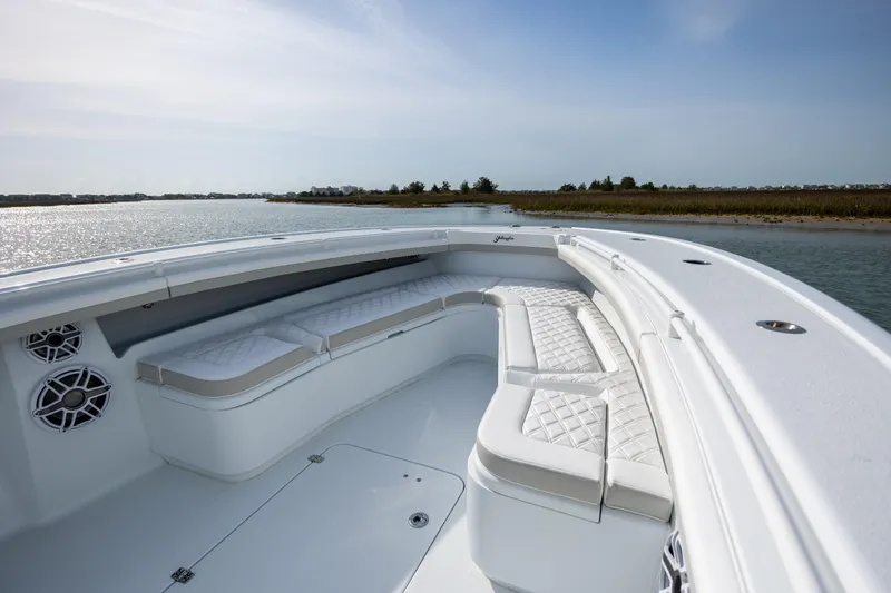 Slide: The Image of 2025 Yellowfin 34 Offshore boat interior with cushioned seating and scenic water view. - 23