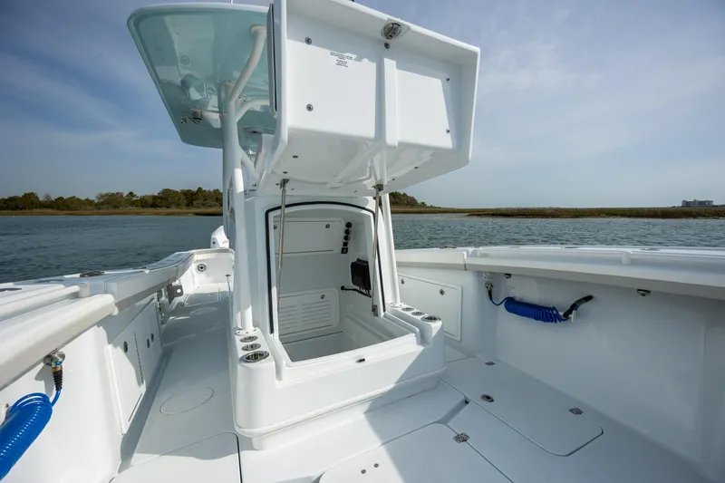 Slide: The Image of 2025 Yellowfin 34 Offshore boat interior with open storage compartment, docked on calm water. - 25