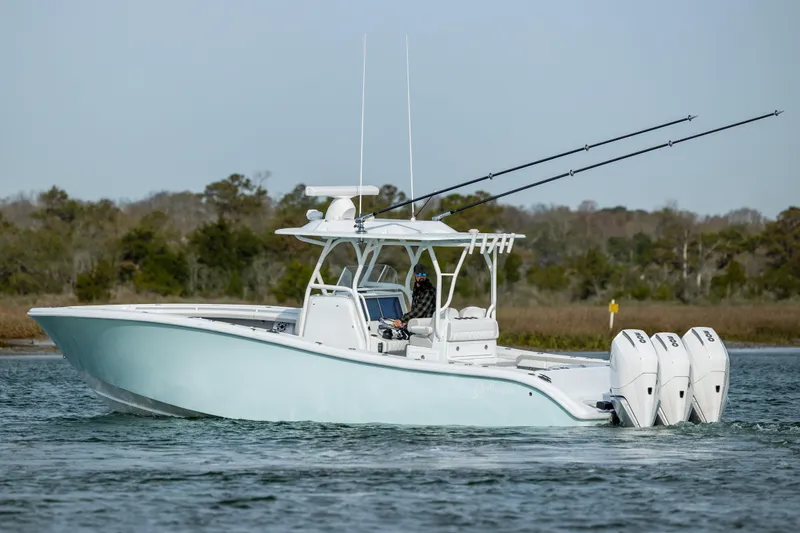 Slide: The Image of 2025 Yellowfin 34 Offshore boat cruising on a calm waterway, rear view. - 7