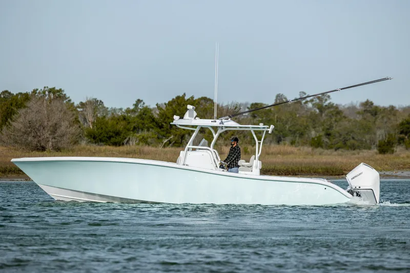 Slide: The Image of 2025 Yellowfin 34 Offshore boat with triple engines cruising on a calm waterway. - 8