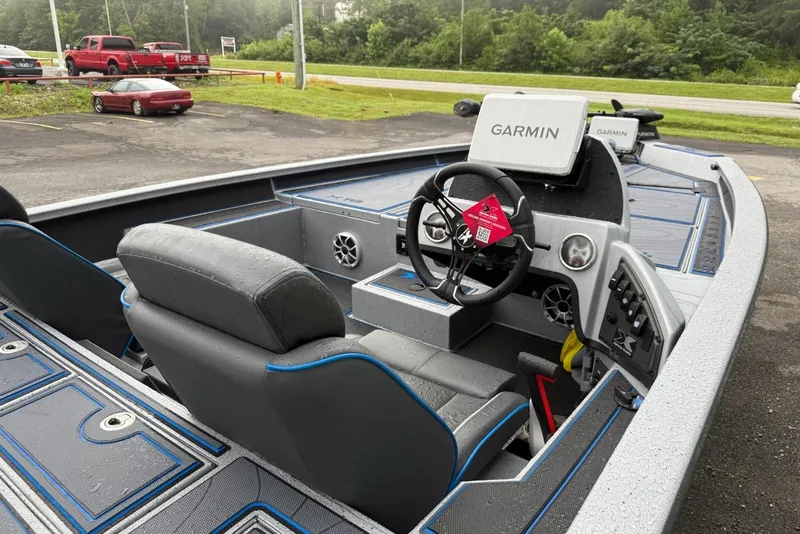 Slide: The Image of 2026 Xpress X19 Pro boat interior with Garmin navigation system, parked outdoors. - 7