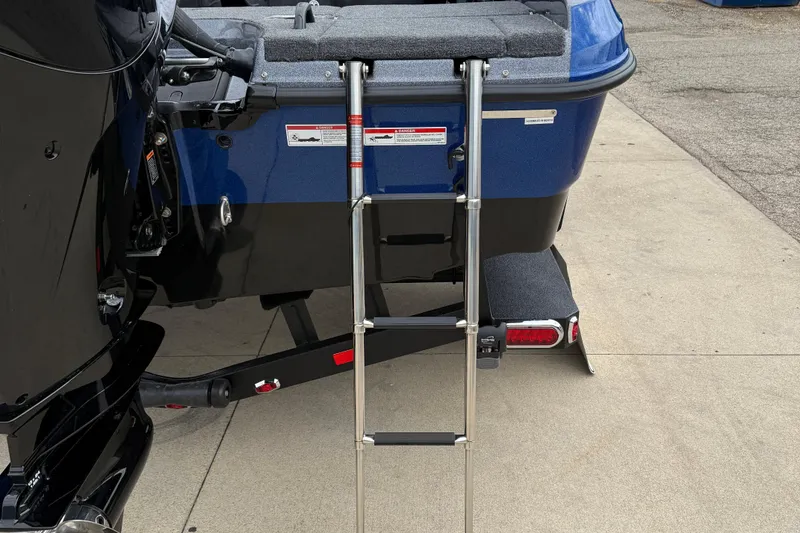 Slide: The Image of 2026 Lund 189 Tyee GL boat with rear ladder and motor, parked on concrete. - 8