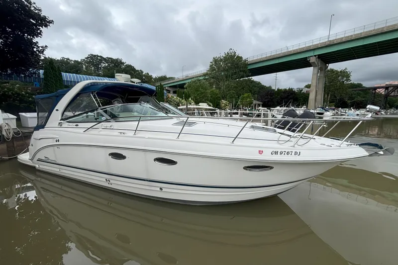 The Image of 2003 Chaparral 310 Signature boat docked near a bridge on a cloudy day. - 0
