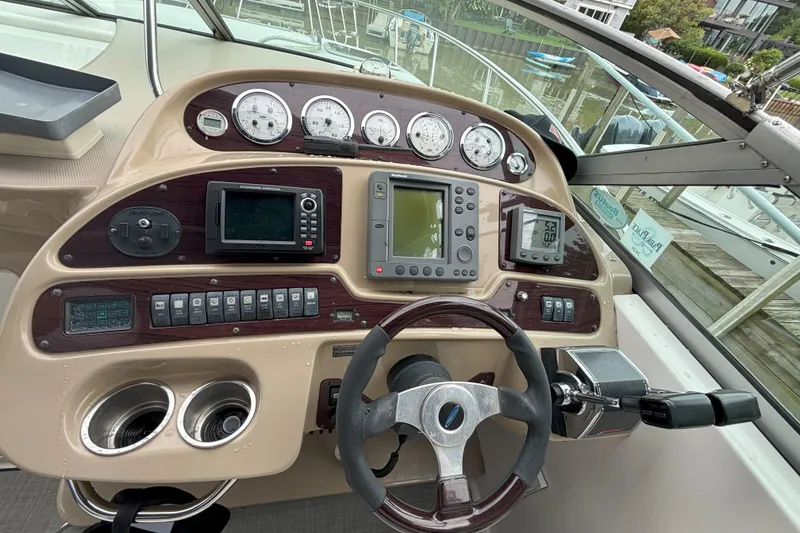 Slide: The Image of Dashboard of a 2003 Chaparral 310 Signature boat with navigation instruments and steering wheel. - 13