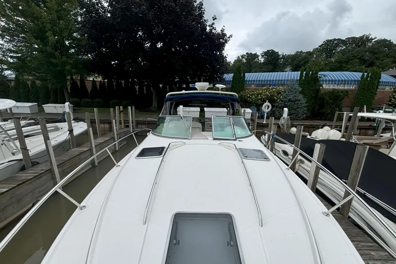 Slide: The Image of 2003 Chaparral 310 Signature boat docked at marina, surrounded by trees and other boats. - 15