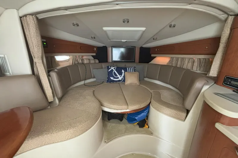 Slide: The Image of 2003 Chaparral 310 Signature cabin interior with seating, table, and nautical decor. - 16