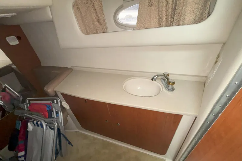 Slide: The Image of 2003 Chaparral 310 Signature boat interior with sink and storage cabinet. - 19