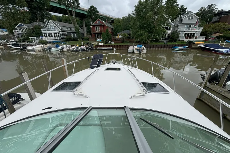 Slide: The Image of 2003 Chaparral 310 Signature boat docked near waterfront homes and other boats. - 2
