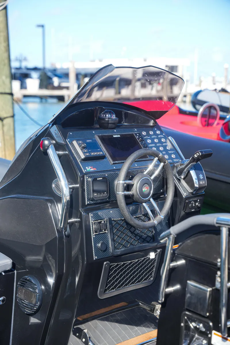 Slide: The Image of 2023 SPX RIB 25 Dinette boat dashboard and steering wheel. - 11