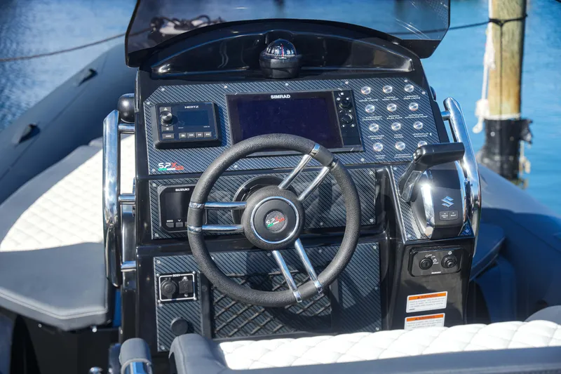 Slide: The Image of Control panel of 2023 SPX RIB 25 Dinette boat with steering wheel and navigation system. - 12