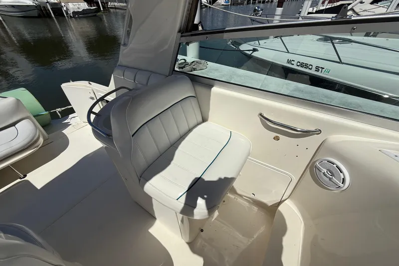 Slide: The Image of 1996 Sea Ray 330 Sundancer boat interior with white seating and waterfront view. - 10