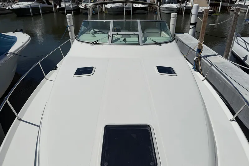 Slide: The Image of 1996 Sea Ray 330 Sundancer docked, showcasing spacious deck and windshield. - 13