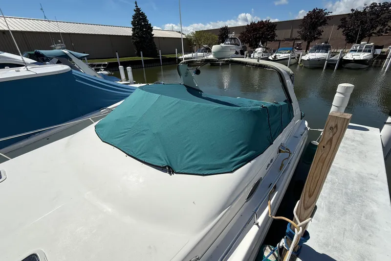 Slide: The Image of 1996 Sea Ray 330 Sundancer docked with teal cover in marina. - 16