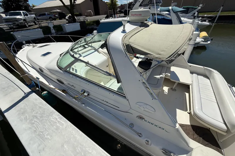 Slide: The Image of 1996 Sea Ray 330 Sundancer docked, featuring spacious seating and canopy. - 2