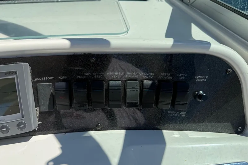 Slide: The Image of Control panel of a 1996 Sea Ray 330 Sundancer boat with various switches and a display. - 20