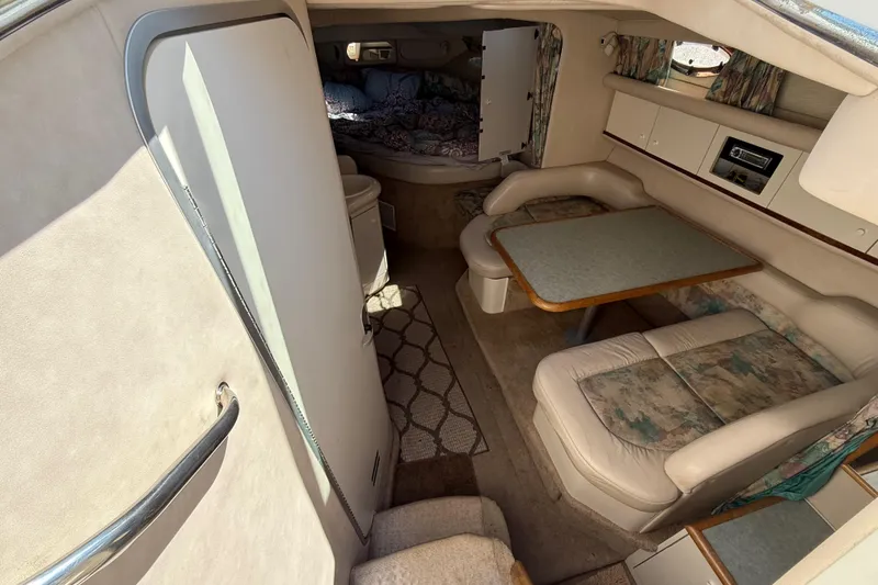 Slide: The Image of Interior of 1996 Sea Ray 330 Sundancer with dining area and cozy cabin space. - 24