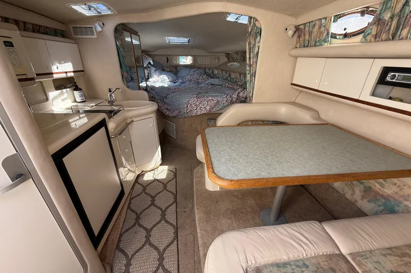 Slide: The Image of Interior of a 1996 Sea Ray 330 Sundancer boat with kitchenette and dining area. - 26