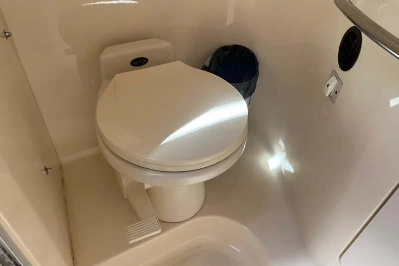 Slide: The Image of 1996 Sea Ray 330 Sundancer boat bathroom with white toilet and foot pedal. - 29